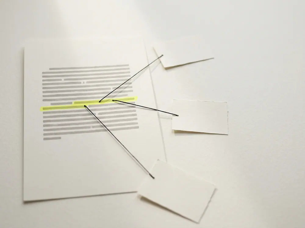 Fosforlu kalemle işaretlenmiş paragraftan çevredeki kartlara uzanan ince iplikler